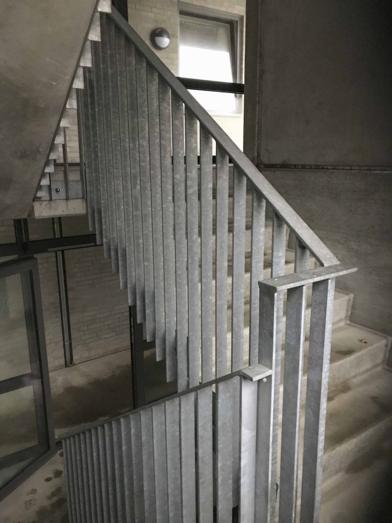 Domicil betontrappe med gelænder i fladstål set inde fra opgangen